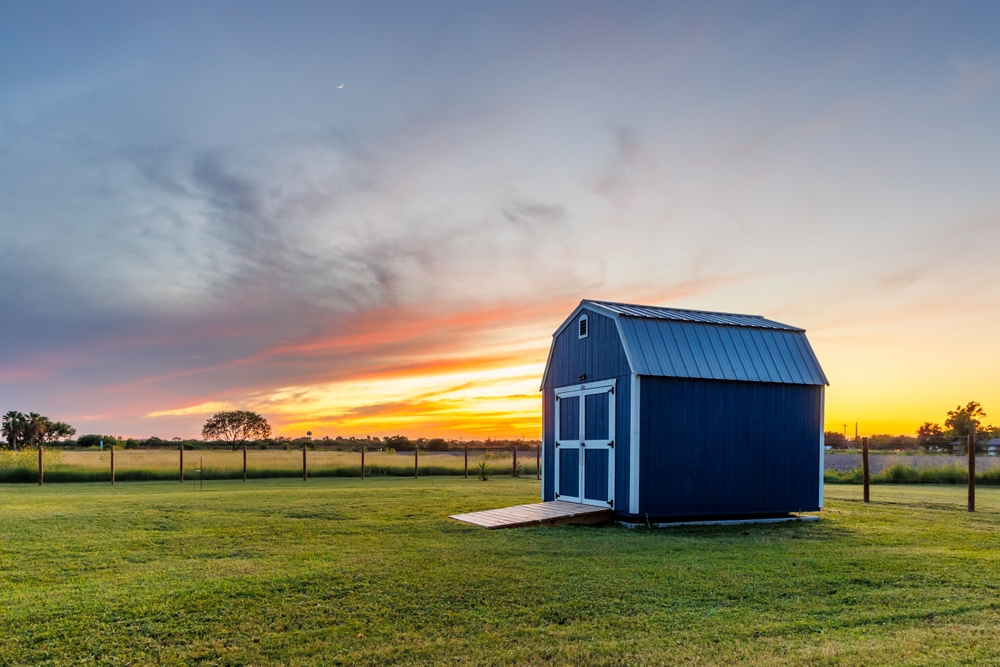 A,Blue,Barn,Style,Shed,In,A,Fenced,Backyard